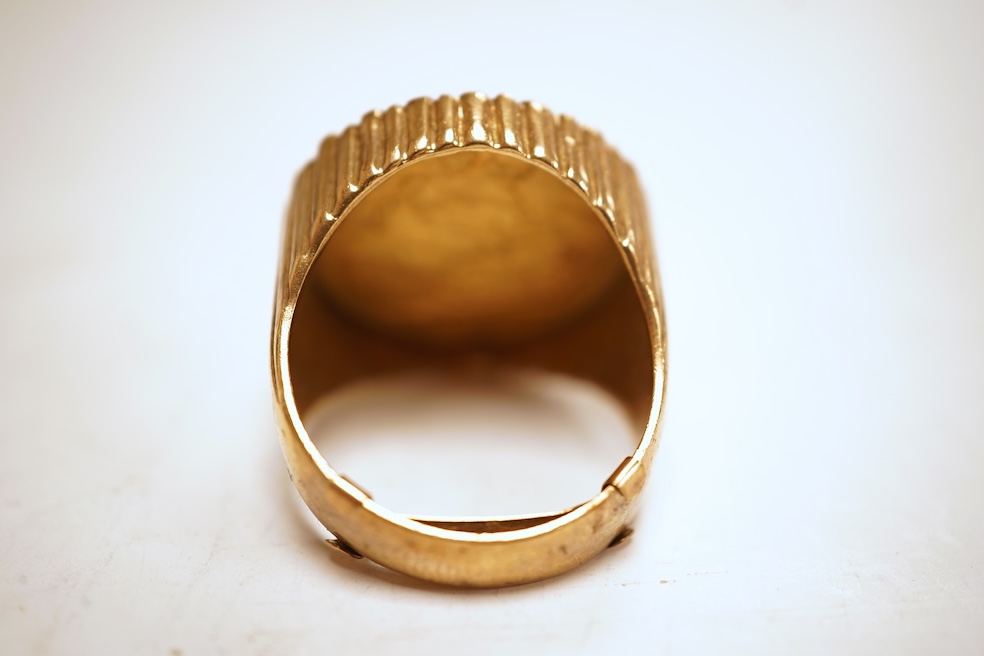 A sovereign ring, 1897 and later, set with a full sovereign dated 1897, to a fluted gold ring mount, size S (sizing band), ring mount stamped 9ct, gross weight 17 grams, Condition: typical surface wear